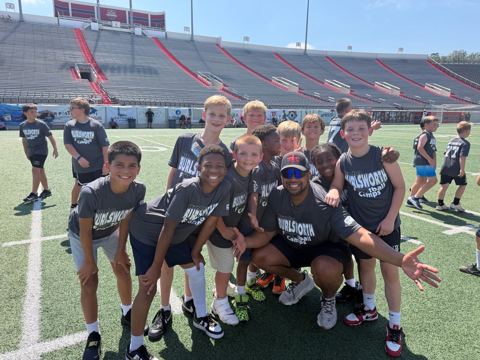 4th & Five volunteers with kids at the Brandon Burlsworth Youth Football Camp